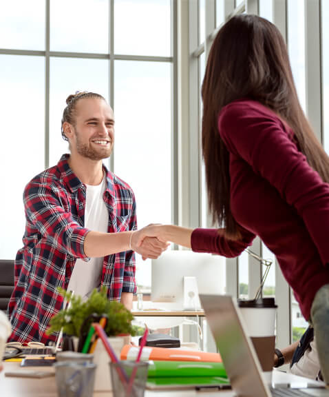 Man happily shaking hands with a woman during meeting
